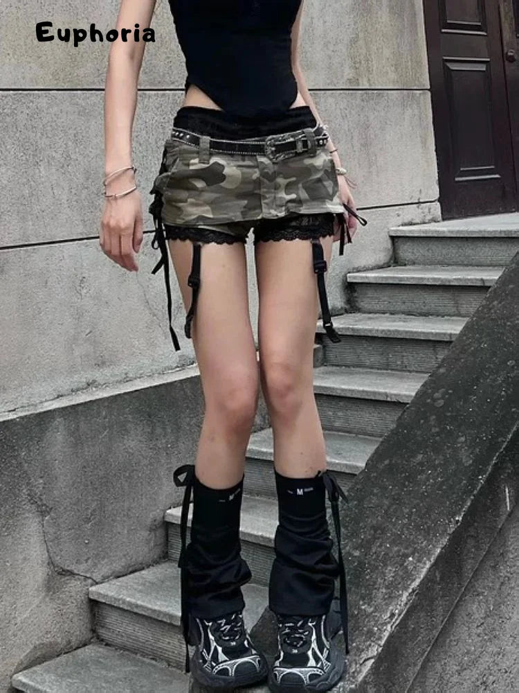 Woman wearing gothic punk camouflage skirt with black lace and belt standing on outdoor steps