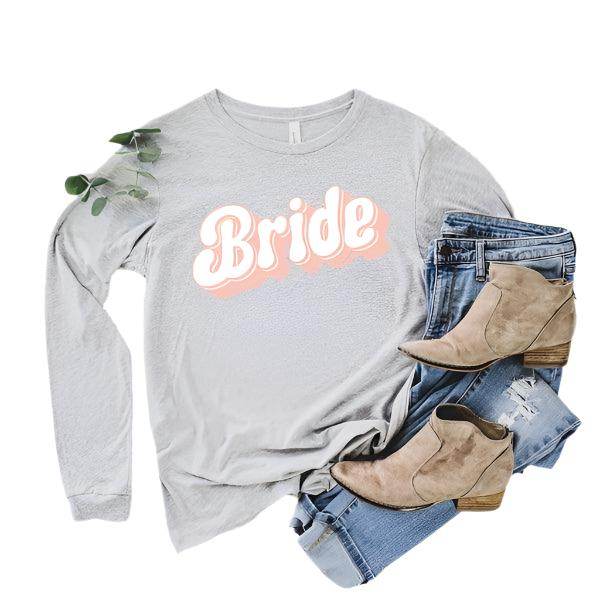 Graphic Bride Shirt Women in light grey featuring stylish text design, paired with jeans and trendy boots