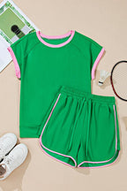 Green two tone tee and shorts set with pink trim by EG fashion laid flat with sports accessories