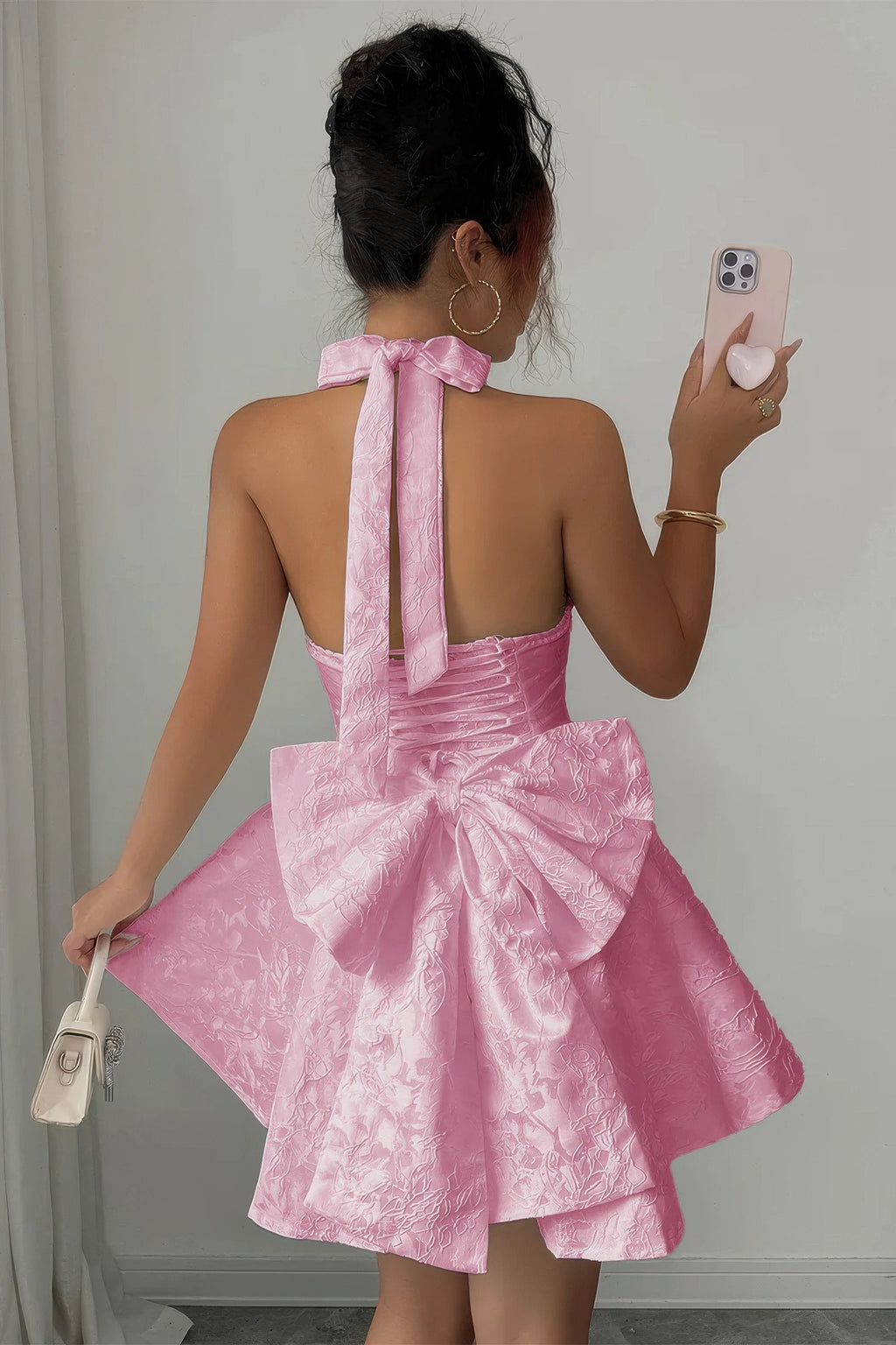 Women's pink halter dress with bow detail, perfect for summer parties
