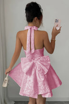 Women's pink halter dress with bow detail, perfect for summer parties