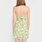 Back view of Emory Park halter neck floral mini dress with a tie design and leafy green pattern