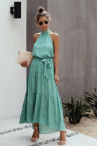Women's halter neck polka dot dress in green with a tiered skirt and matching belt from VacationGrabs