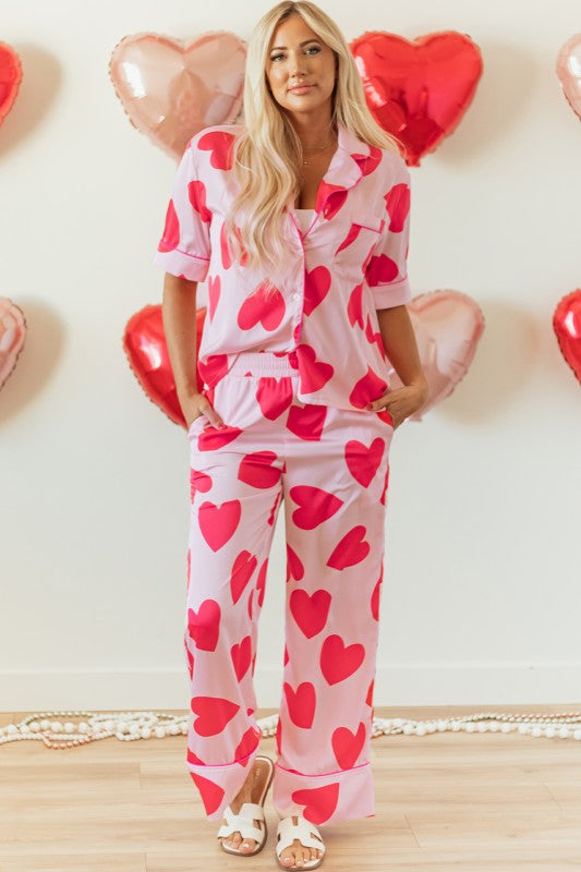 YNIQUE heart print valentine pajamas set with red hearts on pink fabric worn by woman