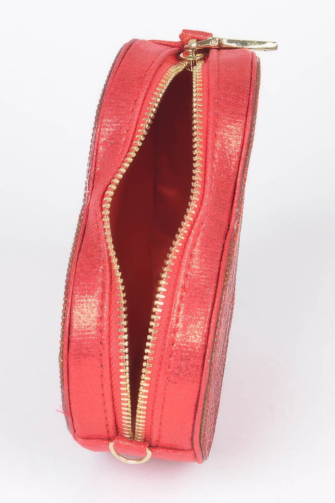 Close-up of a heart shaped evening purse in vibrant red with a gold zipper detail