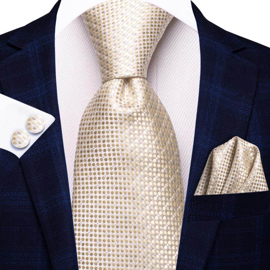 Gold paisley formal tie on a dark navy suit with a matching pocket square and cufflinks