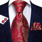 VacationGrabs striped silk necktie in red with intricate gold paisley design, styled with a navy suit