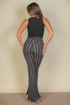 Woman wearing high waist bell bottoms for women with black and white wave pattern paired with black sleeveless top