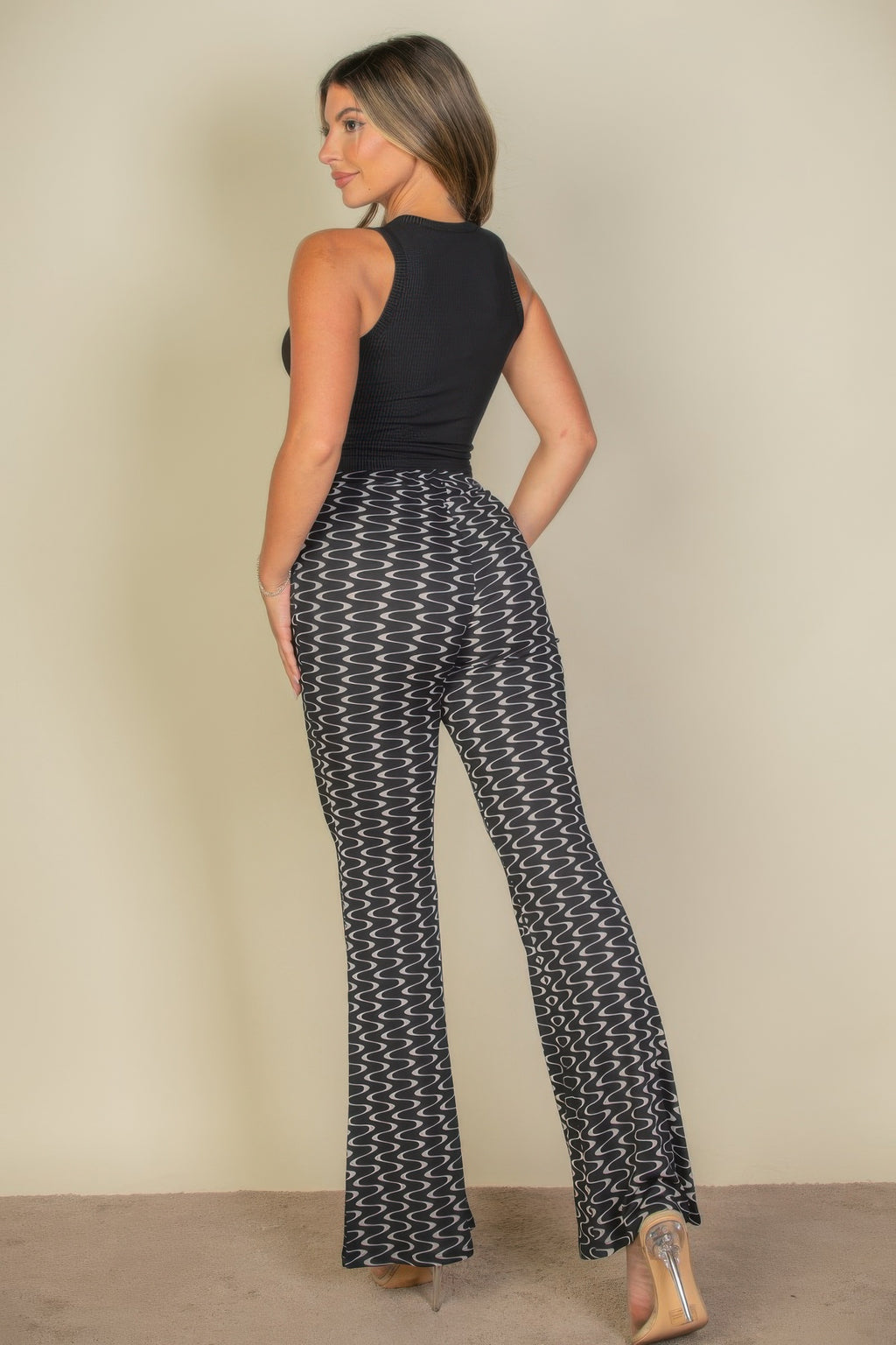 VacationGrabs high waist bell bottoms for women in black and white wavy pattern worn with sleeveless black top