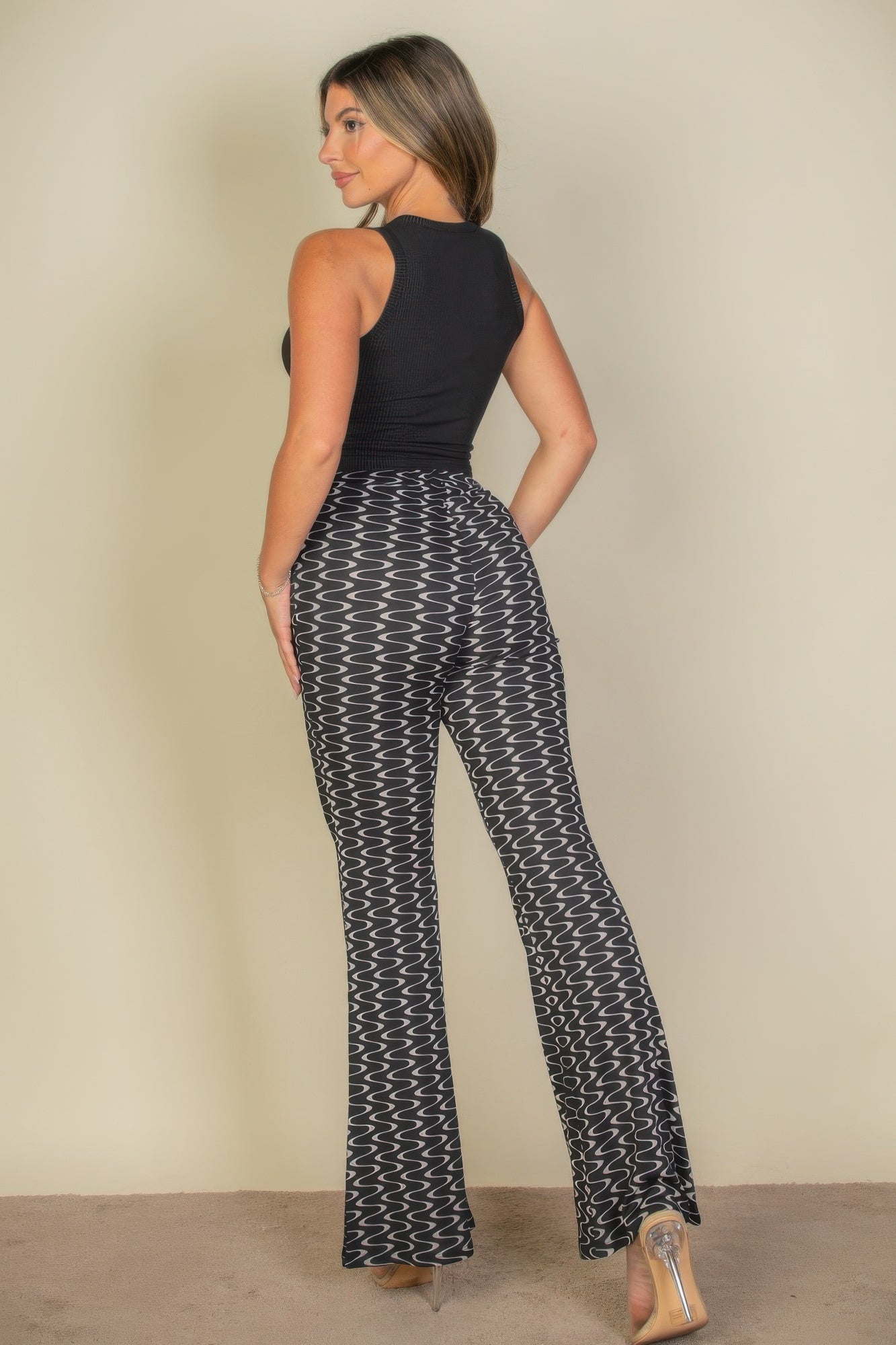 VacationGrabs high waist bell bottoms for women in black and white wavy pattern worn with sleeveless black top