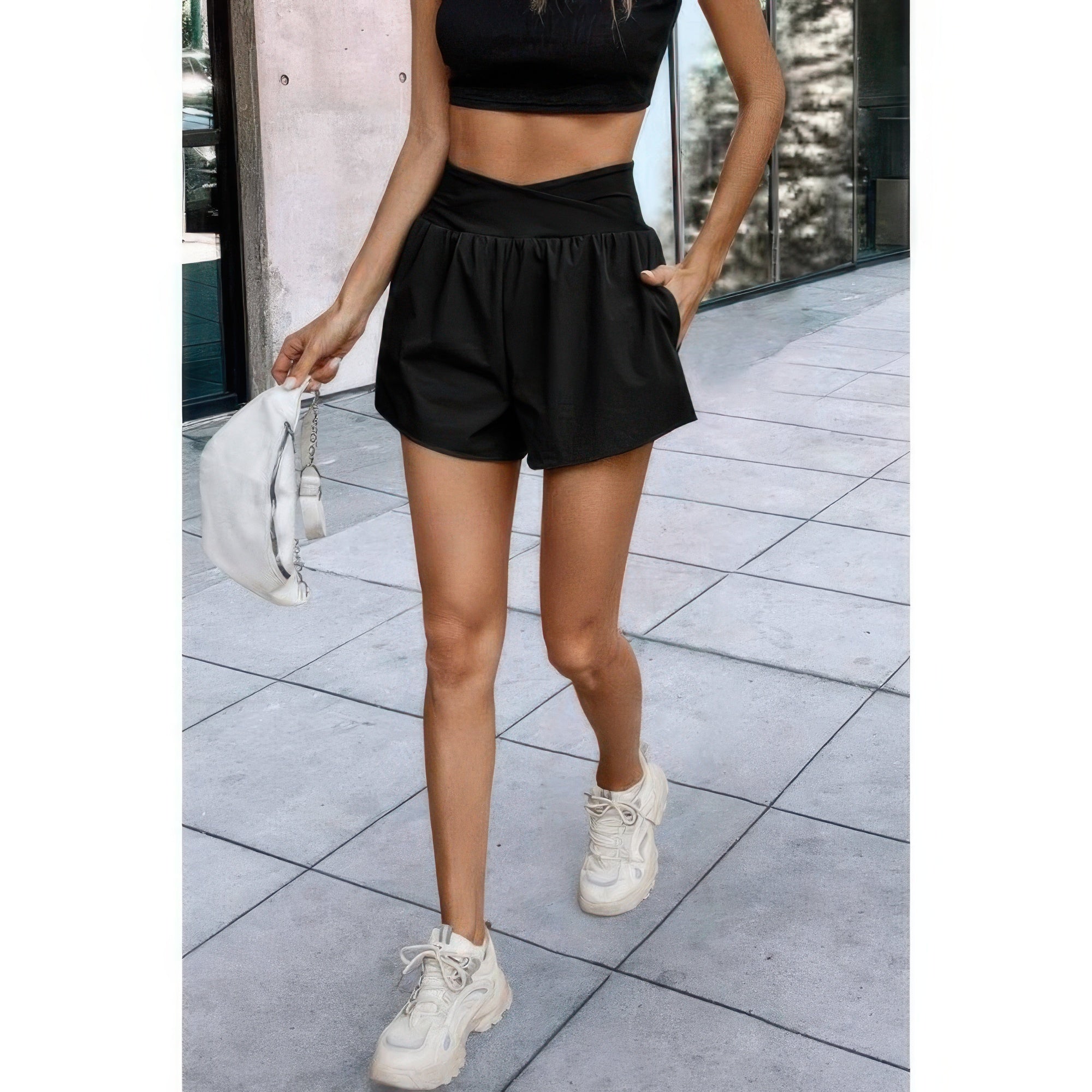 VacationGrabs black high waisted vacation shorts worn with white sneakers and a black crop top