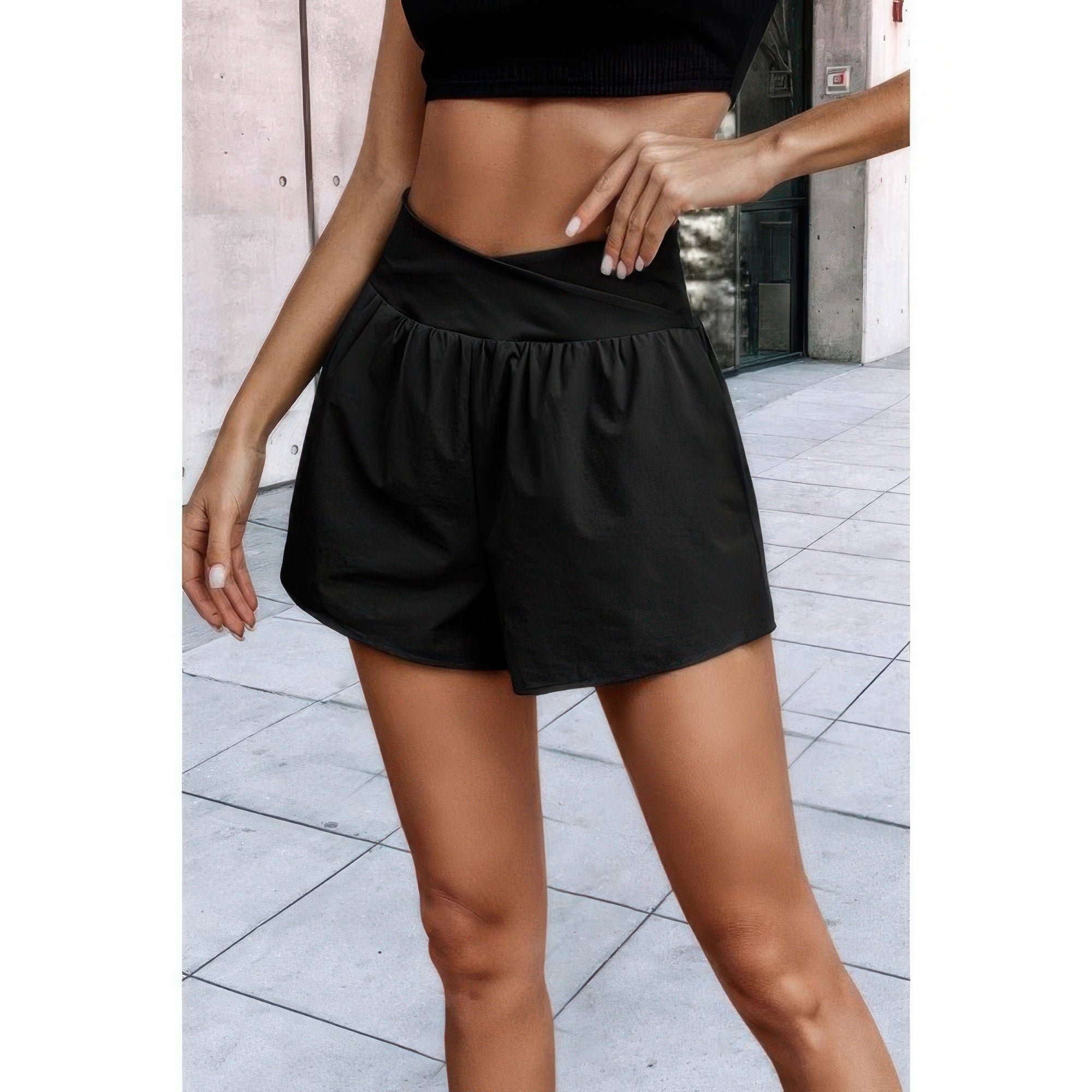 VacationGrabs black high waisted vacation shorts with gathered design on model outdoors