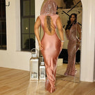 Back view of woman wearing rose gold hooded bodycon dress for women with open back standing indoors