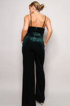 Elegant green holiday party jumpsuit outfit with a fitted top and wide-leg pants