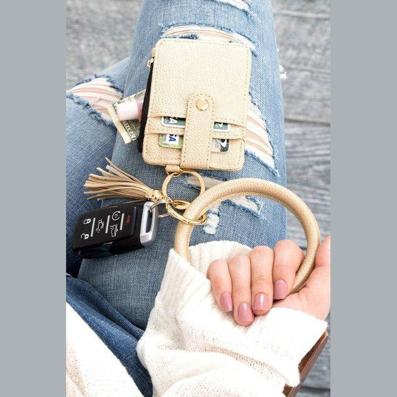 Aili's Corner ID holder keychain bracelet with wallet, money, and car keys on a stylish outfit