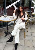 Stylish woman wearing jockey suede boots for women, seated at a cafe in a chic outfit