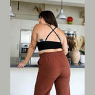Stylish lace high neck top women paired with comfortable brown pants in modern kitchen setting