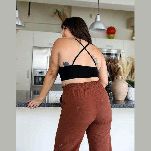 Stylish lace high neck top women paired with comfortable brown pants in modern kitchen setting