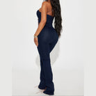 Back view of a Women's lace up denim jumpsuit featuring a flattering design with flared legs