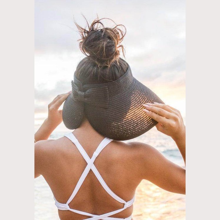 Stylish large brim bow beach hat designed for sun protection and summer fashion.
