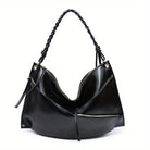 Large handmade shoulder bag in black leather with braided handle and multiple zippered pockets