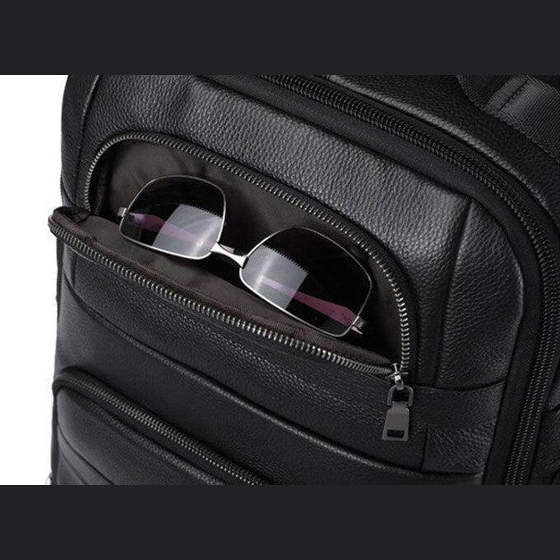 Large leather travel backpack featuring a front pocket for easy access to sunglasses