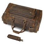Brown leather luggage tote bag with multiple compartments and sturdy handles for travel convenience