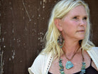 Elegant leather necklace with turquoise pendant worn by a woman, showcasing its unique design and natural beauty
