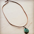 Leather necklace with turquoise pendant, featuring a natural stone charm on a brown cord