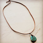 Leather necklace with turquoise pendant, featuring a natural stone charm on a brown cord