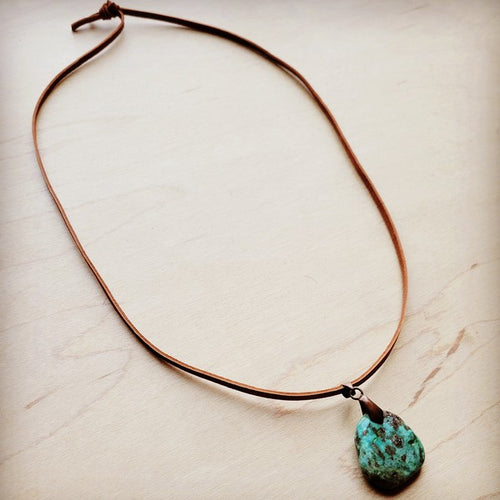 Leather necklace with turquoise pendant, featuring a natural stone charm on a brown cord