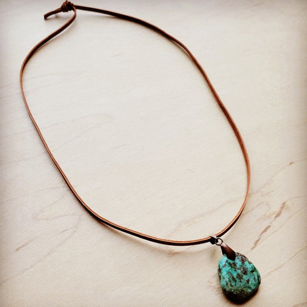 Leather necklace with turquoise pendant, featuring a natural stone charm on a brown cord