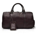 Leather overnight duffel bag in dark brown with sturdy handles and a luggage tag for easy identification