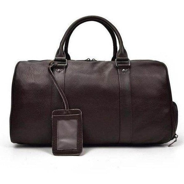 Leather overnight duffel bag in dark brown with sturdy handles and a luggage tag for easy identification