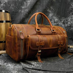 Brown leather weekend bag with shoulder strap featuring sturdy handles and zippered pockets