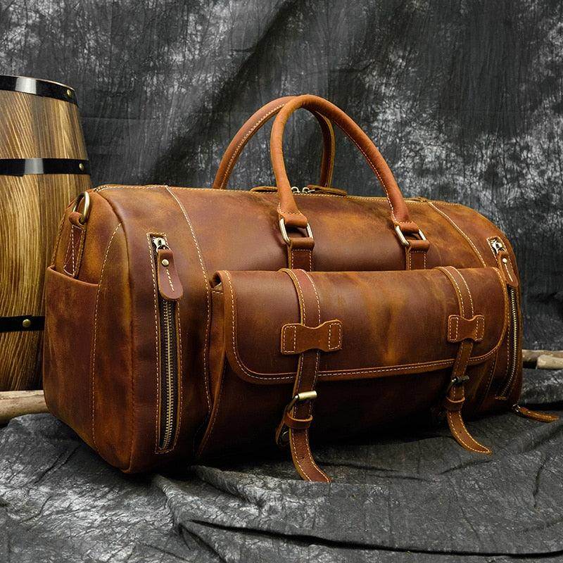 Brown leather weekend bag with shoulder strap featuring sturdy handles and zippered pockets