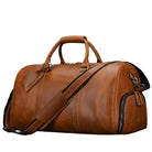 Brown leather weekend bag with shoulder strap, featuring a spacious interior and stylish design