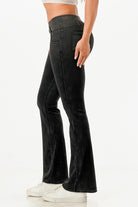 Side view of lightweight flare jeans for women in black, styled with a fitted top and white sneakers