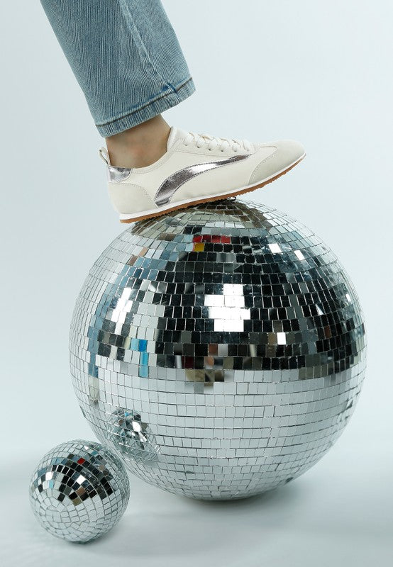 Rag Company lightweight stylish lace up sneakers in white with silver accents on foot over disco ball