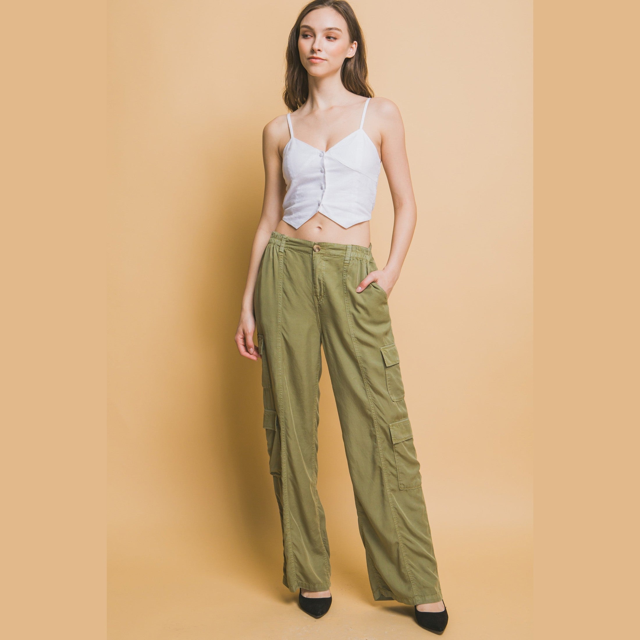 VacationGrabs women's lightweight travel pants with pockets in olive green styled with white crop top