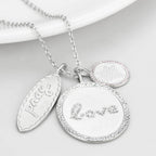 Rhodium brushed brass necklace featuring love and heart charms with sparkling accents
