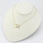 Elegant flash gold brass necklace on display with a smooth rectangular pendant