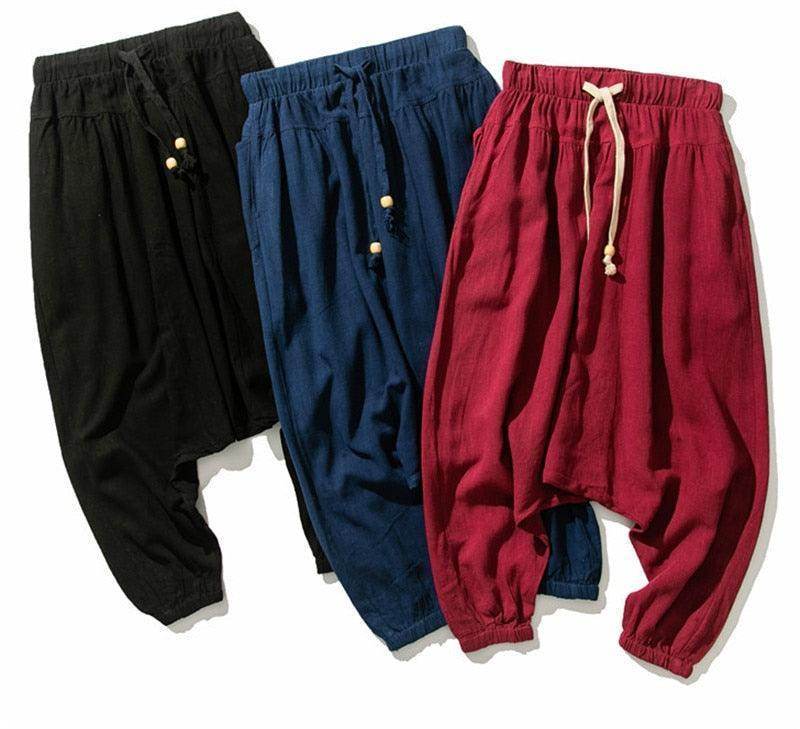 Three pairs of loose fit mens vacation pants in black, navy, and burgundy from VacationGrabs.