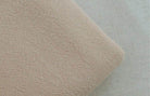 Soft fabric texture of loose fit mens vacation pants in a light beige color by VacationGrabs