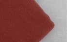 Soft fabric close-up of loose fit men's vacation pants in warm rust color for casual styling