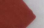 Soft fabric close-up of loose fit men's vacation pants in warm rust color for casual styling