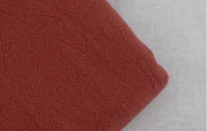 Soft fabric close-up of loose fit men's vacation pants in warm rust color for casual styling