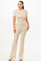 Women's ribbed contrast binding lounge set in beige, featuring a cropped top and relaxed fit pants