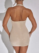 Back view of a woman wearing a beige low-cut evening dress for women with sparkly embellishments