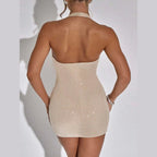 Back view of a woman wearing a beige low-cut evening dress for women with sparkly embellishments